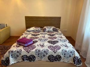 1 cama con 2 almohadas y edredón en Уютная квартира Н.Абдирова 32, en Karagandá