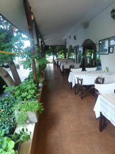 un ristorante con tavoli bianchi e piante in vaso di APARTMENT DELUXE MARINA CAPE 4 stars complex 33 6 ad Aheloy