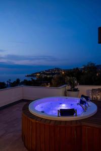 a jacuzzi tub on a balcony at night at Elementa Boutique Hotel - Adults Only in Yalıkavak