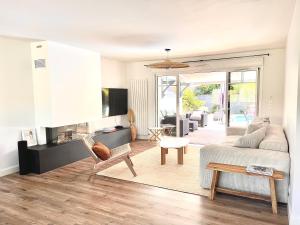 a living room with a couch and a table at Villa Nolaene, 8-9 pers, Piscine, Calme et Moderne in Gujan-Mestras