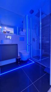 La salle de bains est pourvue de toilettes et d'une douche avec des lumières bleues. dans l'établissement #6 TGHA Luxury Two Bedroom Apartment in Athlone, à Athlone