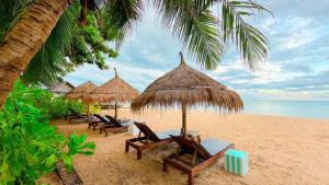 - un groupe de chaises longues et de parasols sur une plage dans l'établissement Margarita Beach, à Khanom
