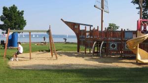 a boy is playing on a playground at the beach at Apartment Keszthely 10 in Bolgárkert