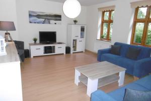 a living room with a blue couch and a table at Ruegen_Fewo 220 in Poseritz