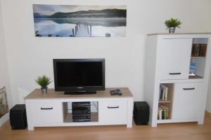a white entertainment center with a flat screen tv on it at Ruegen_Fewo 220 in Poseritz