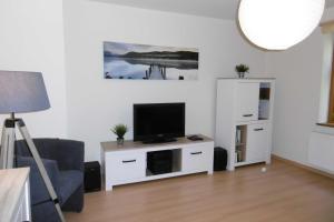 una sala de estar con TV en un armario blanco en Ruegen_Fewo 220, en Poseritz