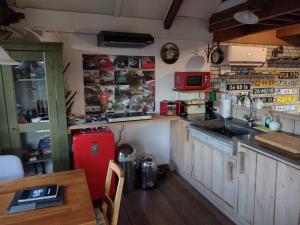 uma cozinha com um frigorífico vermelho e uma mesa em Holiday cottage de Garage Inn em Hank