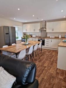 una cucina con un grande tavolo in legno e sedie di 3 Bed House with HOT TUB & 2 Bed Cottage nr Loch Ness a Inverness