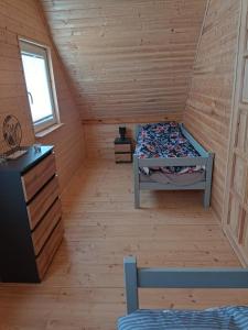 Habitación con cama y escritorio en una cabaña en Drewniany domek na kaszubach u Oli, en Niesiołowice
