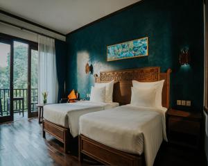 En eller flere senge i et værelse på Amour Resort Bavi