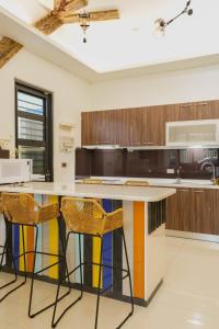 a kitchen with a colorful island with stools at 墾丁包棟民宿-曜凱樂 in Jen-shou