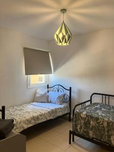 a bedroom with a bed and a chandelier at Serene Oasis @ Arad in Arad