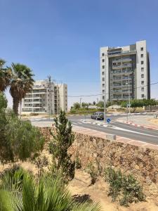 a street with two tall buildings and a road at Serene Oasis @ Arad in Arad