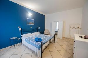 - une chambre bleue avec un lit et un mur bleu dans l'établissement Casa Vacanze Mare Blue, à Vietri