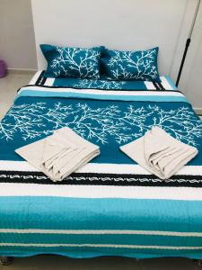 a blue bed with blue and white sheets and pillows at HOMESTAY CIK PHIA in Kuala Terengganu