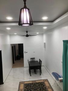 a dining room with a table and a ceiling light at HOMESTAY CIK PHIA in Kuala Terengganu
