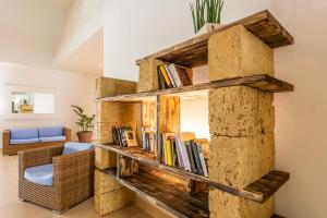 uma estante de livros feita de troncos de cortiça numa sala de estar em VOI Daniela Essentia em Conca Specchiulla
