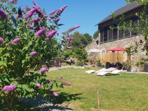 a garden with purple flowers and a building at Tannerie 4 in Lanvallay