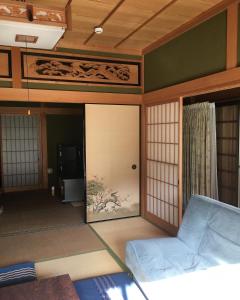 熊野市宿屋Peek-a-Boo的客房设有窗户和沙发。