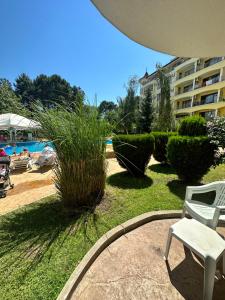 a patio with a chair and a yard with a pool at Summer Dreams C1 in Sunny Beach