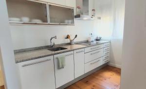 a kitchen with white cabinets and a sink at Casa Tejería. Apartamento Casco Histórico Pamplona in Pamplona