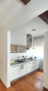 a white kitchen with white cabinets and a sink at Casa Tejería. Apartamento Casco Histórico Pamplona in Pamplona