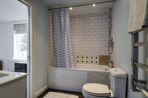 a bathroom with a tub and a toilet and a sink at 1 bed Townhouse in Battersea close to River Thames in London