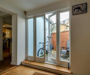 a room with sliding glass doors with a bike outside at 1 bed Townhouse in Battersea close to River Thames in London