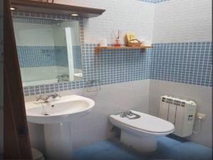 baño de azulejos azules con lavabo y aseo en Hospedería Tía María, en Casillas