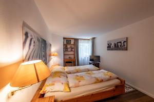 a small bedroom with a bed and a lamp at Chalet Belmont in Flims