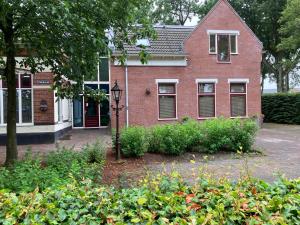 a red brick house with a street light in front of it at Borger appartement in centrum dorp. in Borger