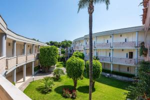 a view of the courtyard of a building with a palm tree at VOI Daniela Essentia in Conca Specchiulla