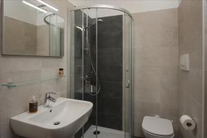 La salle de bains est pourvue d'une douche, d'un lavabo et de toilettes. dans l'établissement Hotel Centrale, à Alleghe