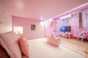 una camera rosa con un grande letto e una stanza per bambini di 宜蘭1955親子民宿一館 a Wujie