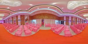 a room filled with pink chairs in a building at Green Mapple in Muzaffarpur