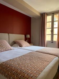 zwei Betten stehen nebeneinander in einem Schlafzimmer in der Unterkunft Hôtel du Musée in Arles + 142 Fotos