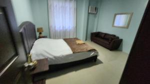 ein Schlafzimmer mit einem Bett und einem Sofa in der Unterkunft Cozy 3Bedroom Home for A Big Family and Friends in Cagayan de Oro