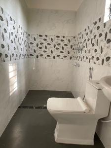 een witte badkamer met een toilet en een wastafel bij Hotel Insta 18 in Siliguri