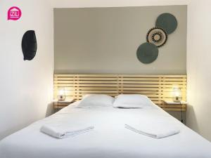 um quarto com uma cama branca e 2 almofadas em Le Nouaillé by iZiLi - Calme et confort - Parking em Poitiers