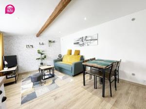 uma sala de estar com um sofá azul e uma mesa em Le Nouaillé by iZiLi - Calme et confort - Parking em Poitiers