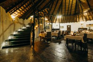 a dining room with tables and chairs and a staircase at Mopane Bush Lodge in Linton
