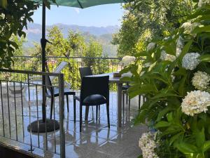 a table with chairs and an umbrella on a balcony at Casa de Casarelhos - Andar da Moradia com terraço - Vistas rio - "Gerês" in Geres