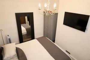 a bedroom with a bed and a flat screen tv at Brighton Inn Boutique Guest Accommodation in Brighton & Hove