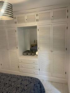 ein Schlafzimmer mit weißen Schränken und einer Kommode in der Unterkunft HACIENDA 12A MENYBER in Nerja