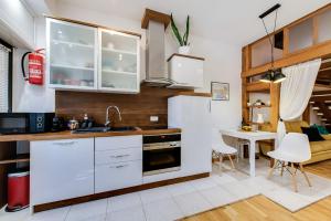 eine Küche mit weißen Schränken sowie einem Tisch und Stühlen in der Unterkunft La Guardia apartment with free private parking in Rijeka