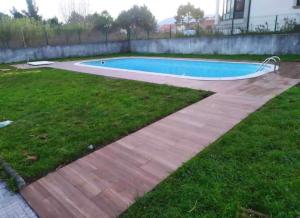 un patio trasero con piscina y césped en O Aserradero, en Finisterre