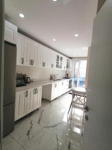 uma cozinha com armários brancos e uma mesa em Spacious and nice apartment em Avcılar