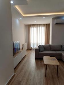 uma sala de estar com um sofá e uma televisão em Spacious and nice apartment em Avcılar