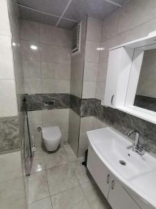 uma casa de banho branca com um WC e um lavatório em Spacious and nice apartment em Avcılar