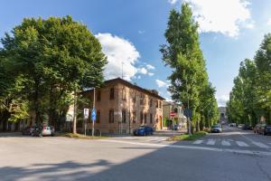 un edificio al lado de una calle con árboles en Ferrara Station Essential Apartment with parking, en Ferrara
